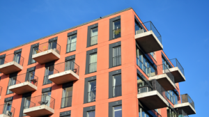 Colorful modern residential building. New luxury house and home complex of red color. City Real estate property and condo architecture.