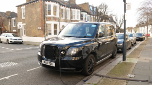 Black Cab Electric vehicle charging at public charging station in London - January,2023. New energy vehicles, eco-friendly alternative energy for cars.