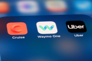 App icons on a phone of Cruise, Waymo and Uber