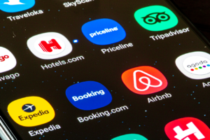 Close up view of various travel app, icons, logo displayed on a smartphone, Booking.com, Airbnb, Hotels.com, Agoda, Tripadvisor, Priceline, Expedia, Trivago. Uber expedia super app