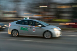 Bolt taxi in motion, Toyota Prius with blurred background, motion blur. Bolt legal battle. Bolt employment rights ruling.